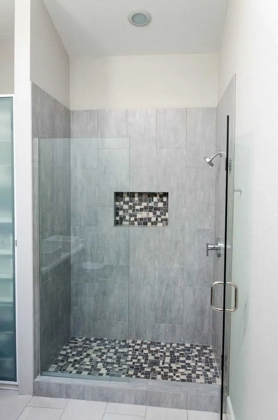 Spacious walk-in tile shower with frameless glass door