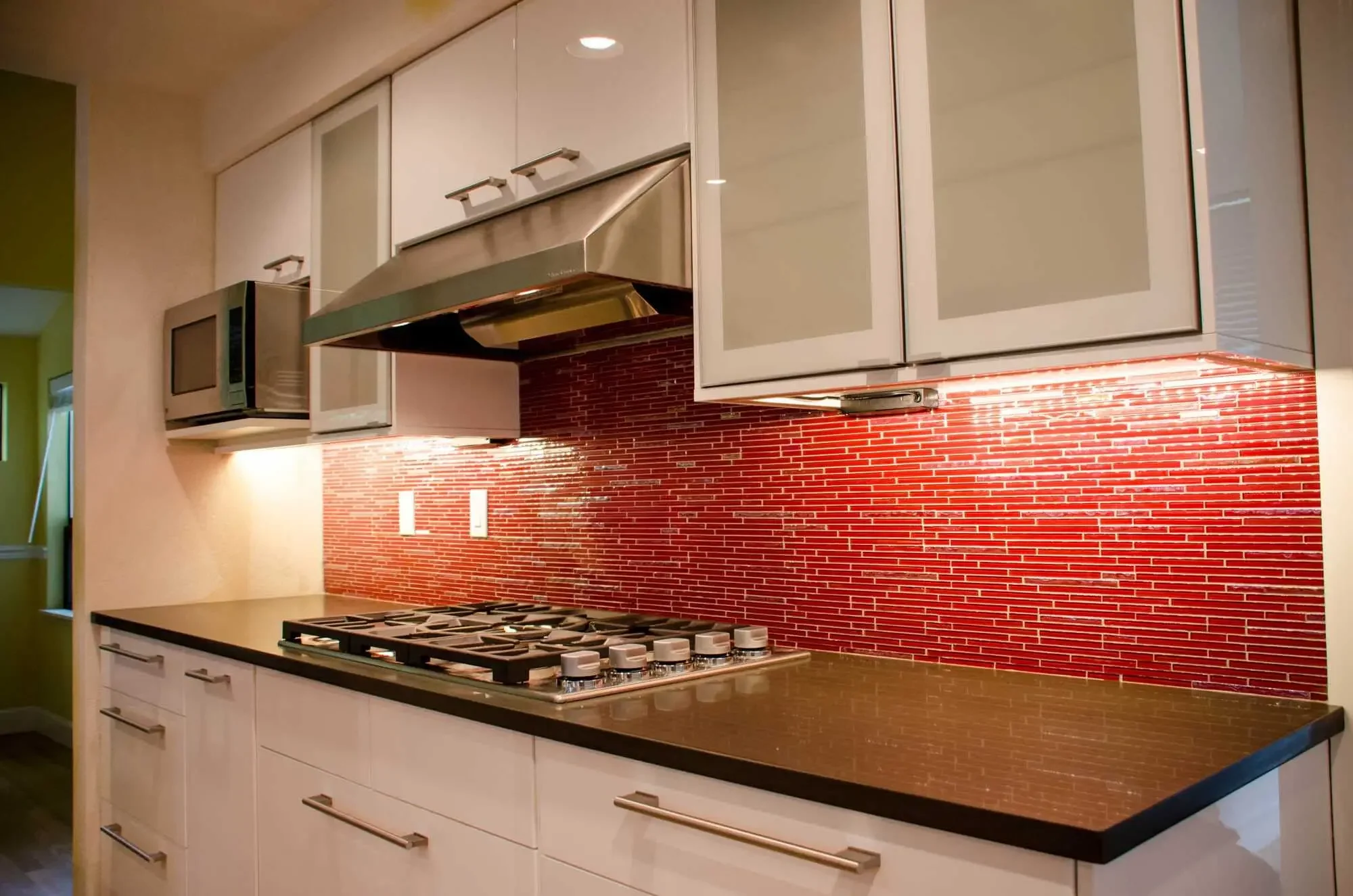 The red glass mosaic backsplash was a bold choice, but it really works here!