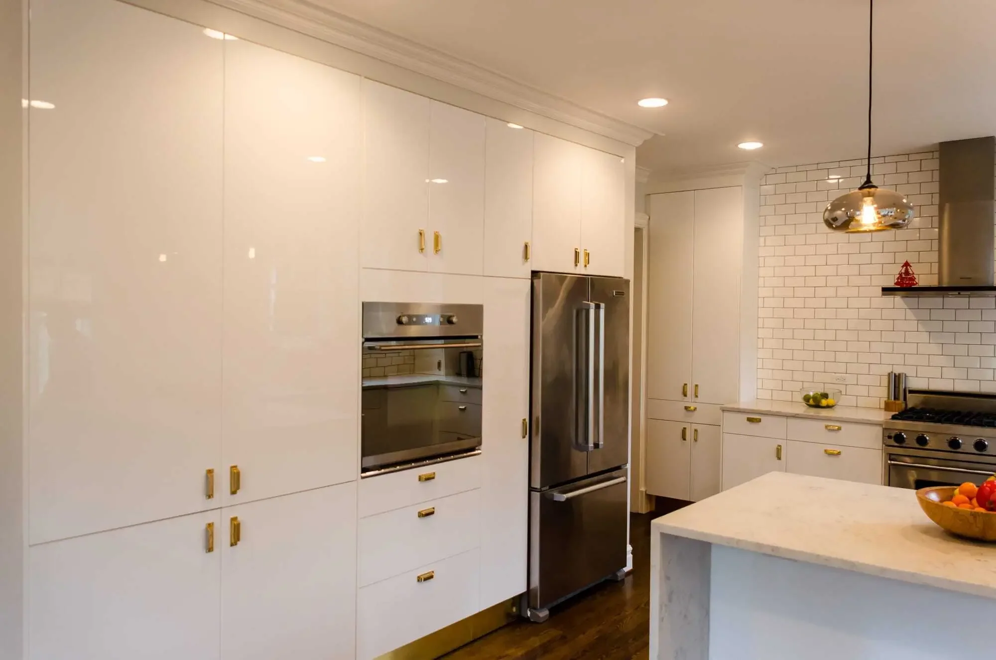 Modern IKEA kitchen with high-gloss white doors and brass pulls
